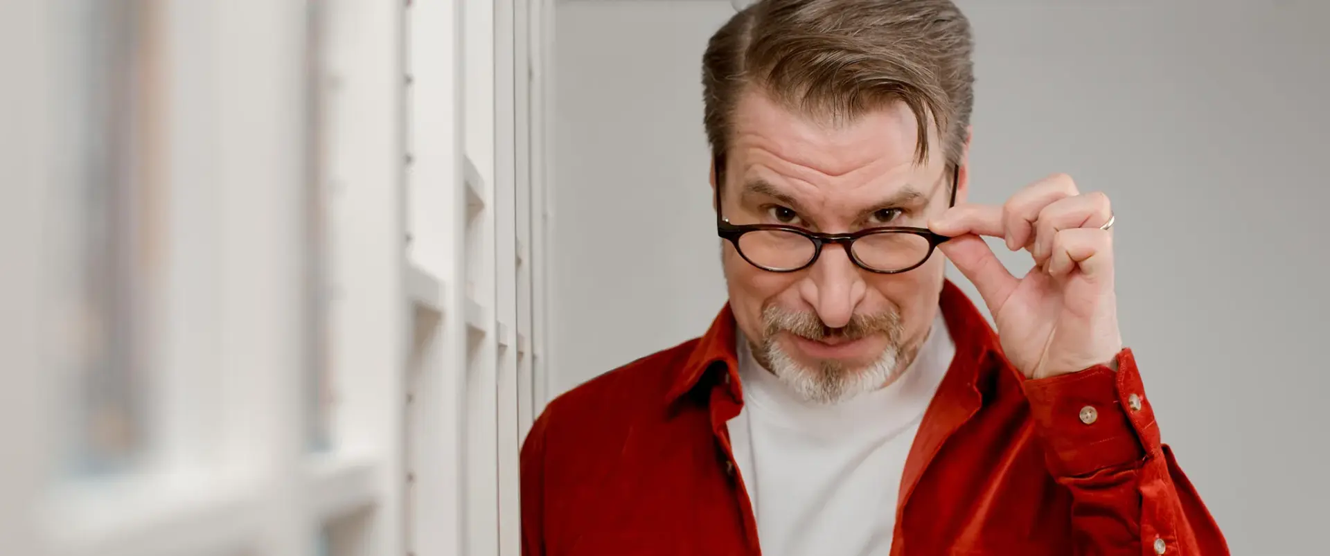 Schauspieler Karsten Oliver blickt über den Brillenrand – Baden-Württemberg, 2026.
