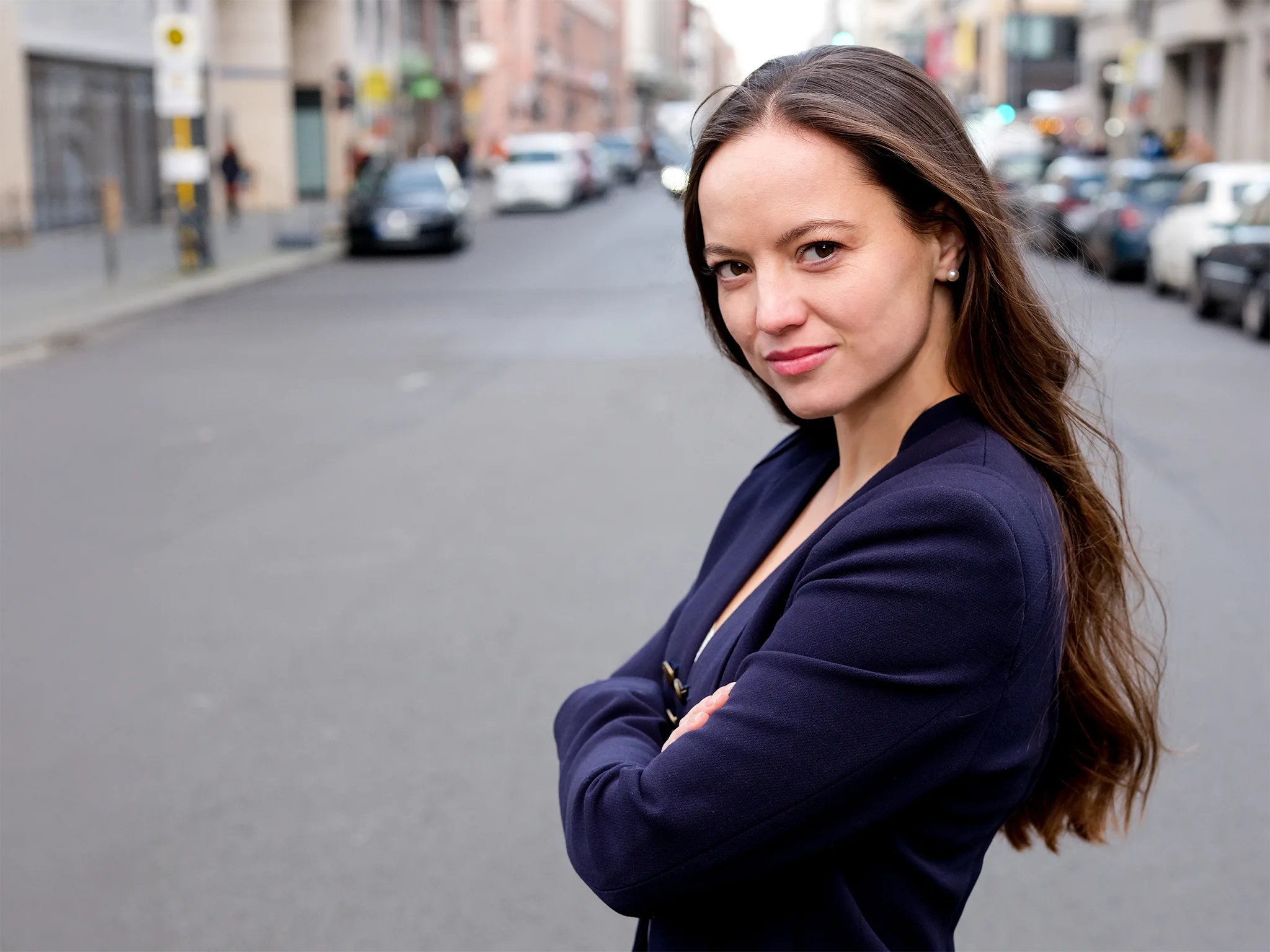 Schauspielerin Theresa Kempf steht selbstbewusst auf einer Stadtstraße.