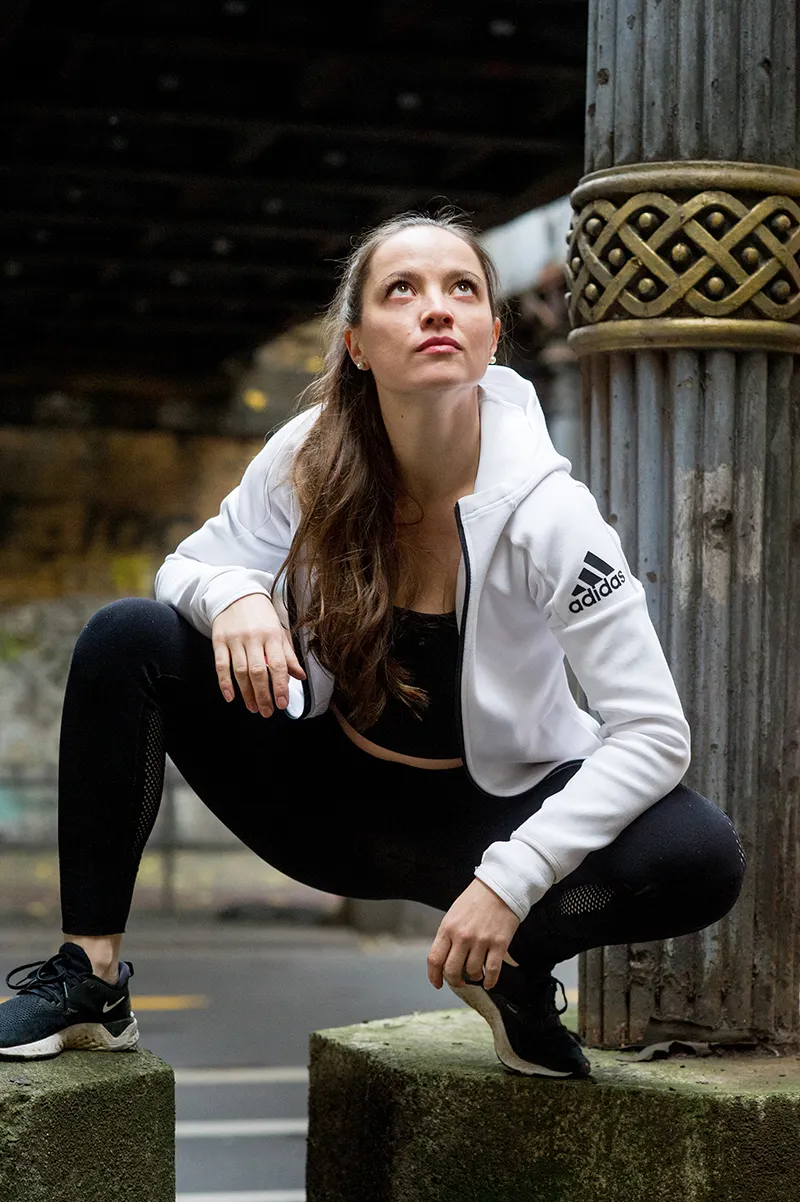 Schauspielerin Theresa Kempf hockt im urbanen Unterführungs-Portrait.